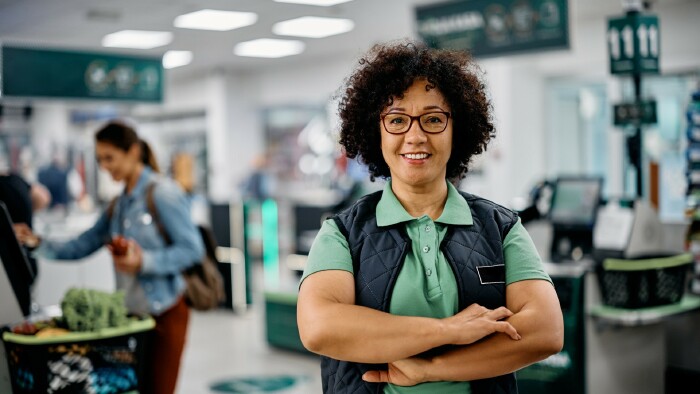 Portr&auml;t einer selbstbewussten Verk&auml;uferin im Supermarkt und Blick in die Kamera