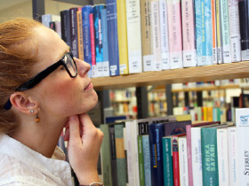 Frau stöbert in Bibliothek