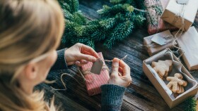 Junge Frau packt Geschenke für Weihnachten ein.