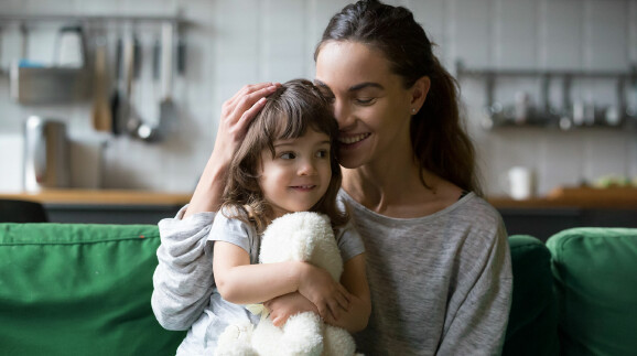 Alleinerziehende Mutter, die Tochter umarmt