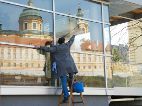 Reinigungskraft beim Fensterputzen