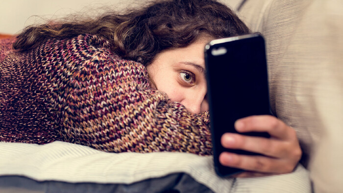 Junges M&auml;dchen surft am Smartphone.