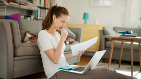 junge Frau betrachtet Rechnungen