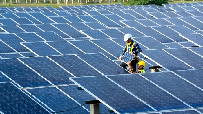 Zwei Ingenieure &uuml;berpr&uuml;fen und warten Solarbatterien