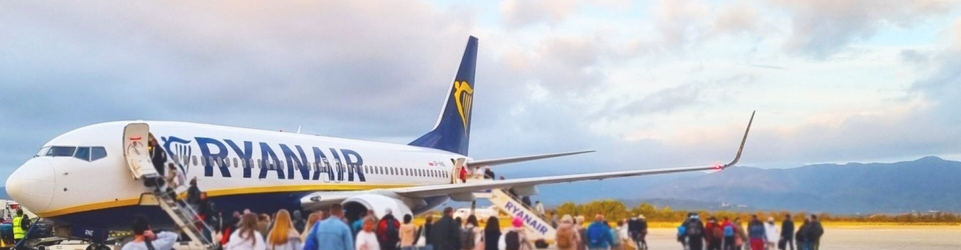 Passagiere stehen vor einem Ryanair-Flugzeug in der Schlange.
