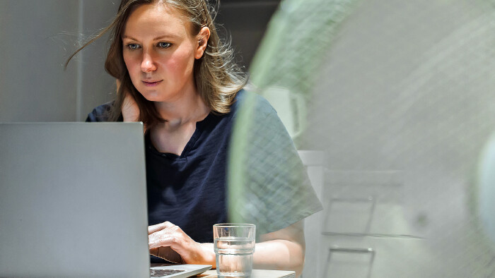 Junge Frau arbeitet im Büro bei Hitze
