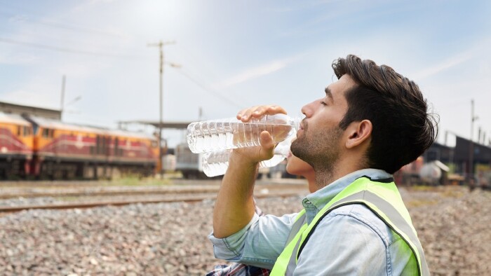Arbeiter trinkt Wasser aus einer Flasche