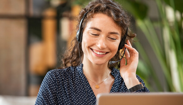 Beraterin telefoniert mit Headset und lächelt